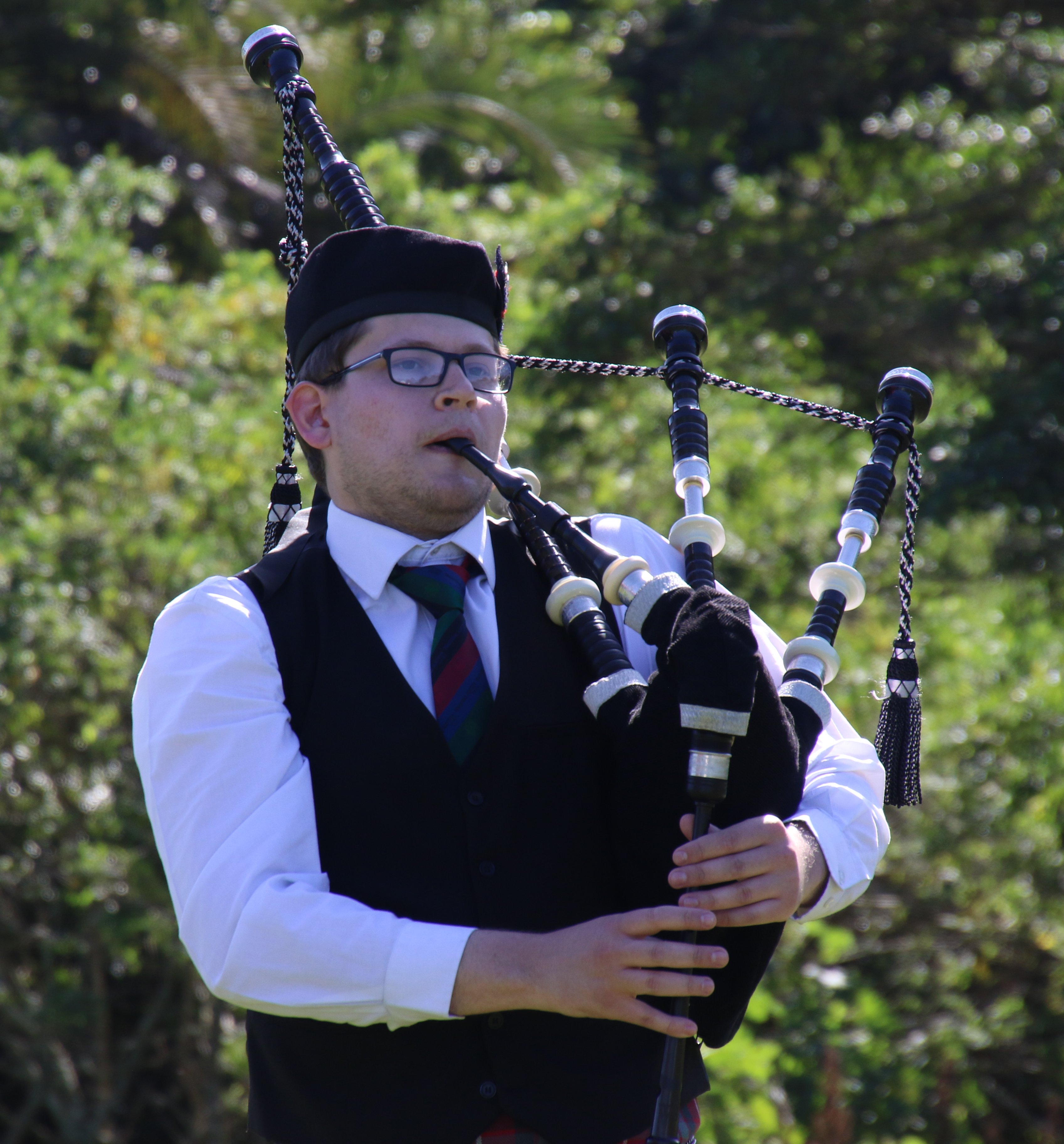 Alex playing bagpipes in traditional Scottish attire